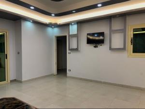 a room with white walls and a tv on the wall at قريه نڤيرت in Fayed +1 photo