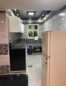 a kitchen with a refrigerator and a stove at قريه نڤيرت in Fayed