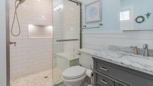 a bathroom with a toilet and a shower and a sink at Little Cottage On Lafayette in Cape May +14 photos
