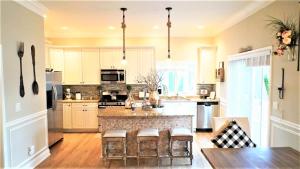 a kitchen with white cabinets and a large island with bar stools at 717 Broadway in West Cape May