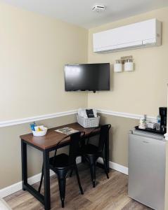 a room with a table and two chairs and a television at Nestle Inn in Hermann