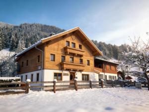 a house in the snow with a fence at Kitzbüheler Alpen XL in Bramberg am Wildkogel