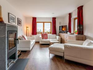 a living room with white furniture and a fireplace at Kitzbüheler Alpen XL in Bramberg am Wildkogel