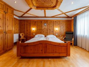 a bedroom with a large bed in a room with wooden walls at Kitzbüheler Alpen XL in Bramberg am Wildkogel