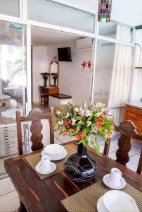 a dining room table with a vase of flowers on it at Vallartasol Hotel in Puerto Vallarta