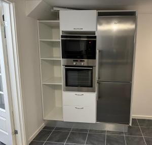 a kitchen with a refrigerator and a microwave at Møller Guesthouse in Ilulissat