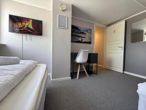 a bedroom with a bed and a chair in it at Møller Guesthouse in Ilulissat
