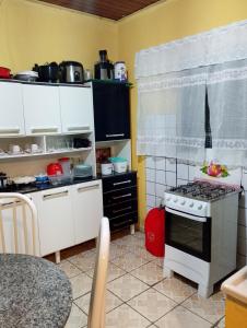 a kitchen with white cabinets and a stove at Casa simples em cunha in Cunha