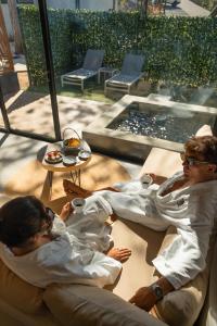 two men sitting on a couch next to a table at Epic Tamarindo Boutique Hotel in Tamarindo +190 photos