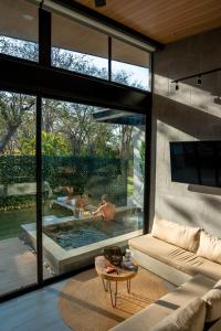 a living room with a couch and a swimming pool at Epic Tamarindo Boutique Hotel in Tamarindo