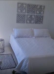 a bedroom with a white bed with white sheets and pillows at Departamento Tierralta in Malagueño