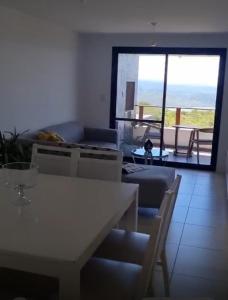 a room with a table and chairs and a living room at Departamento Tierralta in Malagueño