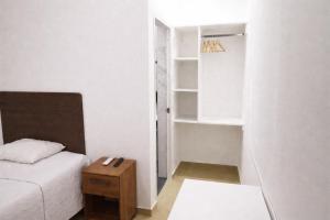 a small bedroom with a bed and a table at La casa de Isabel in Tarapoto