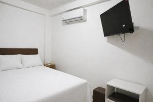 a bedroom with a bed and a tv on the wall at La casa de Isabel in Tarapoto