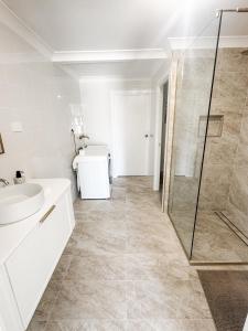 a bathroom with a shower and a sink and a toilet at Beach Bungalow Yeppoon in Yeppoon +15 photos