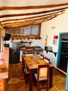 a dining room with a table and a kitchen at Casa Garaje in Barichara