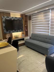 a living room with a couch and a tv at El lujo y la comodidad in Zipaquirá