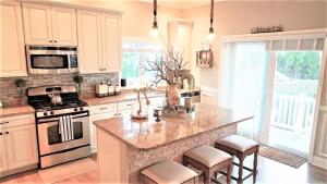 a kitchen with white cabinets and a island with stools at 717 Broadway in West Cape May +13 photos