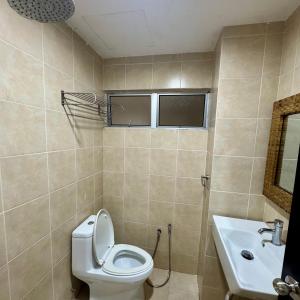 a bathroom with a toilet and a sink at Gold Coast Morib Apartment in Banting +7 photos