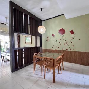 a dining room with a table and flowers on the wall at Gold Coast Morib Apartment in Banting
