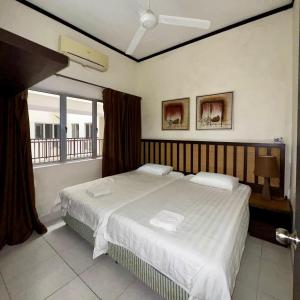 a bedroom with a large bed and a window at Gold Coast Morib Apartment in Banting
