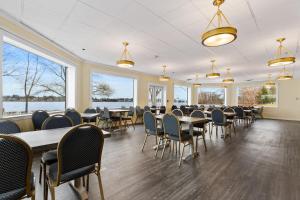 a dining room with tables and chairs and windows at Lakeside Inn in Wakefield