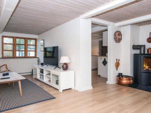 a living room with a fireplace and a table at House with beautiful garden in Glesborg