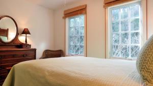 a bedroom with a bed and a mirror and windows at 639 Seagrove in Cape May Point
