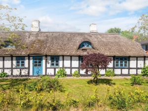 an old house with a thatched roof at House with beautiful garden in Glesborg