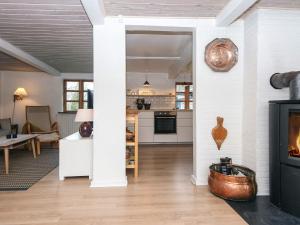 a living room with a fireplace and a kitchen at House with beautiful garden in Glesborg