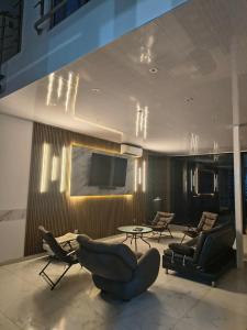 a living room with chairs and a flat screen tv at RICAURTE CASA PISCINA PRIVADA in Ricaurte