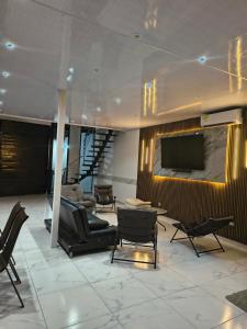 a living room with chairs and a flat screen tv at RICAURTE CASA PISCINA PRIVADA in Ricaurte