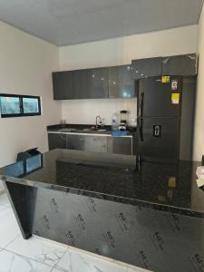 a kitchen with a black refrigerator and black counter top at RICAURTE CASA PISCINA PRIVADA in Ricaurte