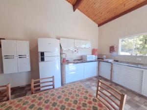 a kitchen with white appliances and a table and chairs at Chácara Florida Boituva in Boituva