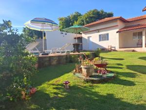 a yard with two umbrellas and a yard with a house at Chácara Florida Boituva in Boituva