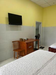 a bedroom with a desk and a television on the wall at Tan My Thien Hotel in Tây Ninh