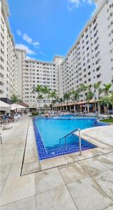 a large hotel with a swimming pool in front of a building at Boulevard suíte hotel suíte 1220 in Caldas Novas