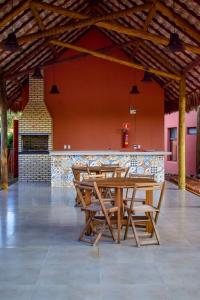 a wooden table and chairs in front of a bar at Ap 101 concept BobZ in Barrinha