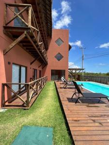 a building with a swimming pool next to a house at Ap 101 concept BobZ in Barrinha