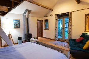 a room with a bed and a couch and a window at sika lodge in Wareham