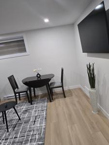 a dining room with a table and chairs and a tv at Cozy 1-Bedroom Private Basement Suite in Winnipeg with separate entrance in Winnipeg
