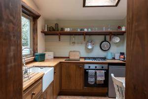 a kitchen with wooden cabinets and a stove top oven at sika lodge in Wareham