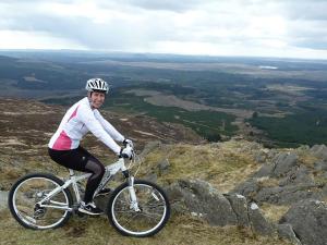 a man riding a bike on top of a mountain at Culsharg Cottage in Bargrennan +11 photos