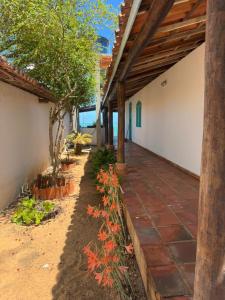 a porch of a house with a tree and flowers at Casa bela vista in Icapuí