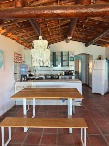 a kitchen with a table and a white refrigerator at Casa bela vista in Icapuí