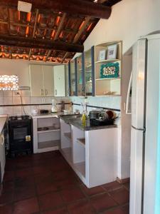 a kitchen with white cabinets and a refrigerator at Casa bela vista in Icapuí