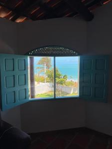 a window in a room with a view of the ocean at Casa bela vista in Icapuí