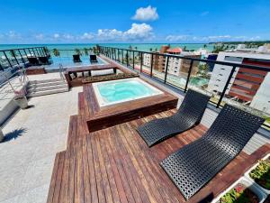 a balcony with a hot tub and two chairs at Cabo Branco - Legacy Suítes in João Pessoa