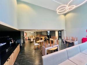 a restaurant with chairs and tables and a bar at Cabo Branco - Legacy Suítes in João Pessoa