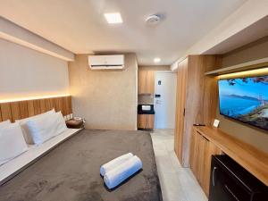 a hotel room with a bed and a flat screen tv at Cabo Branco - Legacy Suítes in João Pessoa +27 photos